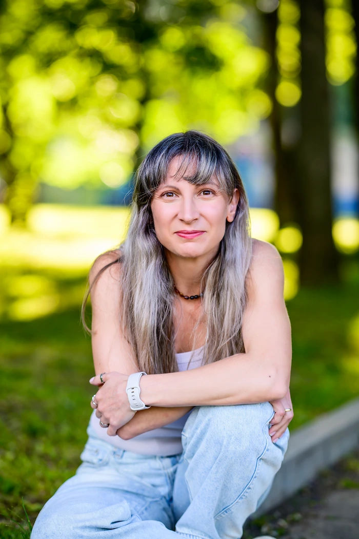 Зорница Гълъбова, психолог и създател на Here With You Now, седнала на тревата в парк